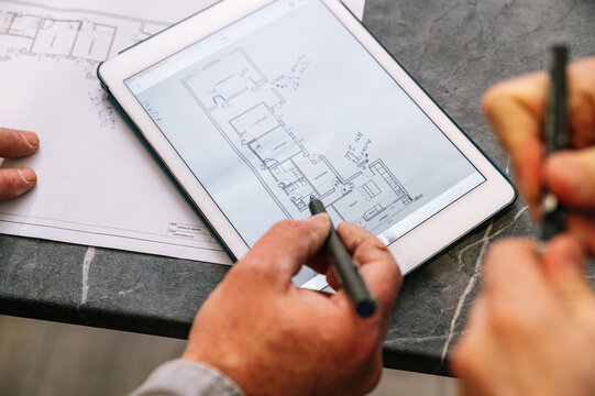 Crop architects examining draft on tablet