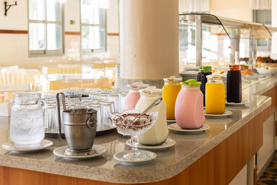 Fresh summer buffet table with juices, yoghurt, milk and ice cubes
