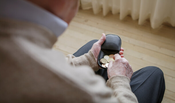 Senior man looking for money in his wallet