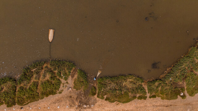 drone photo of a fisherman with net at the river