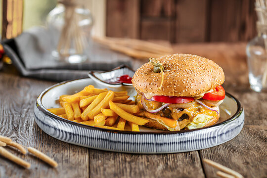 Gourmet portion of burger set with fries on wooden background