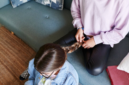 Teen girl braiding her friends hair