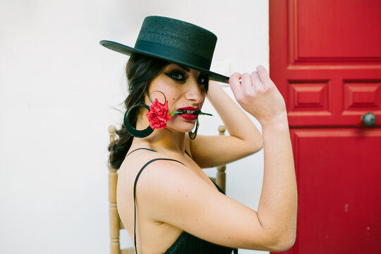 Portrait of a flamenca woman with a red carnation on the mouth
