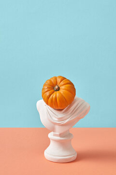 Plaster statue with head in the shape of pumpkin.