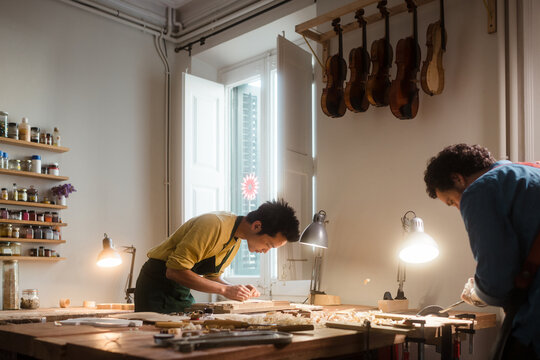 Young luthiers working at their violin workshop