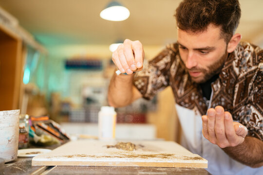 Skilled master making miniature beach