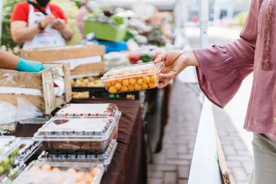 Female hand holding a case of fruit at a market