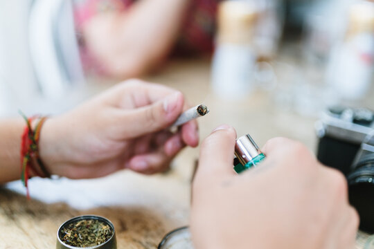 Hands lighting a joint