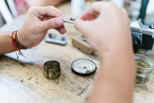Hands putting marihuana in rolling paper