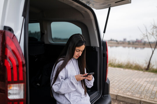 teenage girl with mobile phone in a van