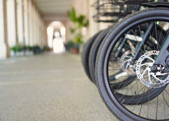 Bottom view of wheels and handlebars of electric bicycles available for rent to tour the city and be eco-sustainable, ecofriendly concept, 0 emissions, electric means of transportation
