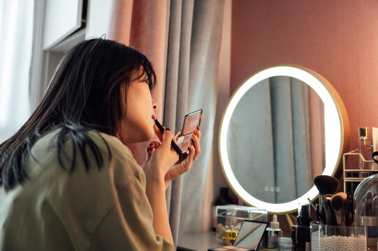 Young woman applying makeup in the morning