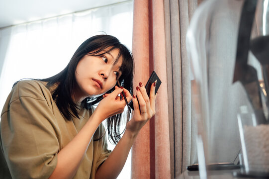 Young woman applying makeup in the morning