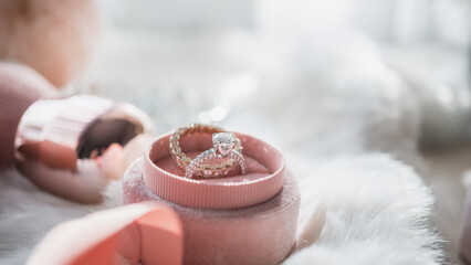 Close up of diamond ring in the pink box with sunlight and shadow. Love, valentine, relationship and wedding concept. Soft and selective focus.
