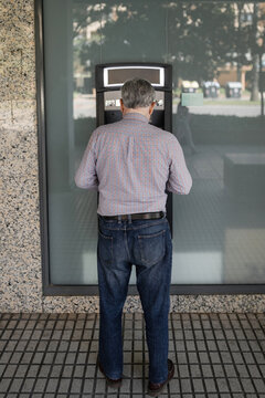 senior man at an ATM withdrawing cash