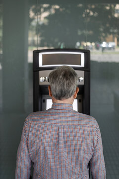 senior man at an ATM withdrawing cash