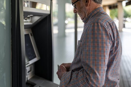senior man at an ATM withdrawing cash