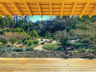 serene view from the inside of a wooden dojo looking out at a lush japanese garden park