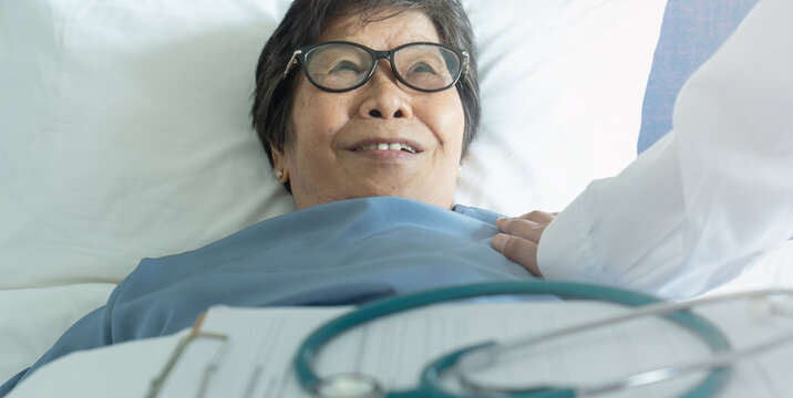 Geriatric doctor or geriatrician concept. Doctor physician hand on inpatient elderly senior patient to comfort in hospital examination room or hospice nursing home or wellbeing county.