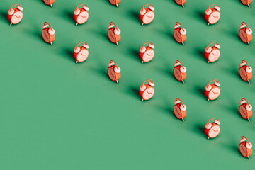 many pink alarm cloks covering half of the green background