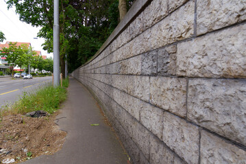 Diminishing perspective of outside stone wall of cemetery at City of Zürich on a cloudy spring day. Photo taken May 19th, 2022, Zurich, Switzerland.