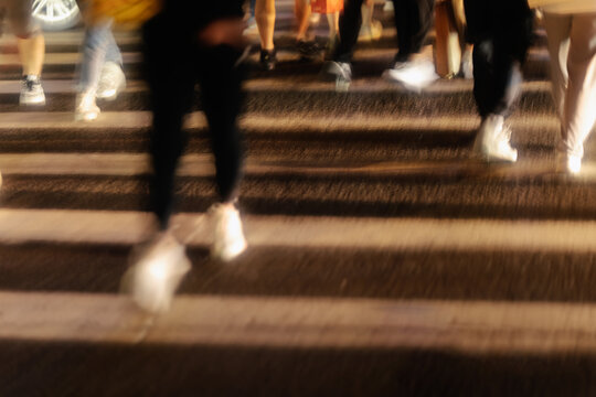 Passersby crossing zebra crossing at night
