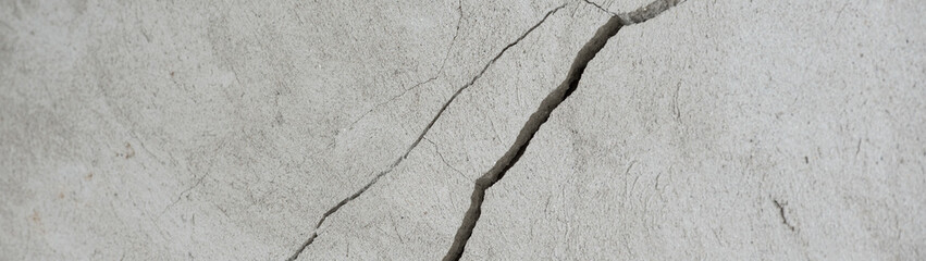 Diagonal crack in plaster on a wall panoramic banner
