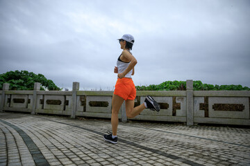 Fitness woman runner running at seaside