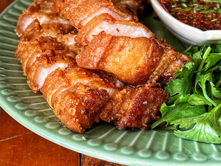 Deep-fried Pork Belly with Fish Sauce served with dipping sauce. Thai food that can be eaten as a snack or as a side dish. Closeup food photo.