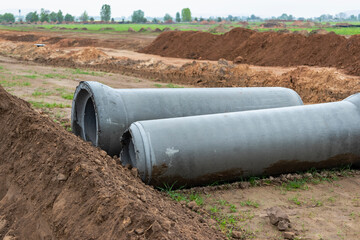 Reinforced concrete storm sewer pipes of large diameter stacked at a construction site. Sewer Large...