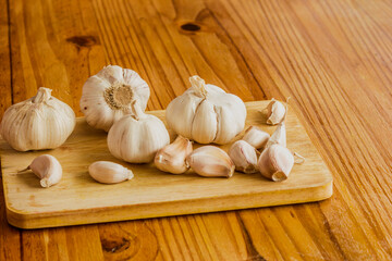 Garlic is a culinary and medicinal plant on a wooden background