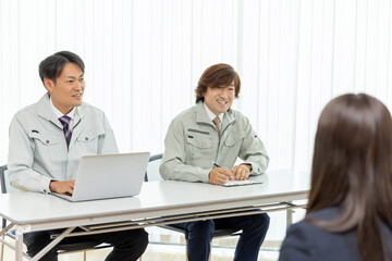 Obraz premium 面接をする作業着をきたビジネスマン 