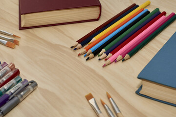 Obraz premium books pencils fountain pens and brushes for drawing on the table concept education school