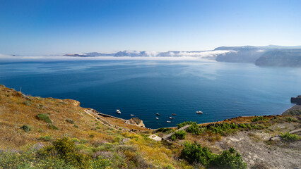 A panoramic view of Santorini's caldera from south to north with a small fishing harbour in the...