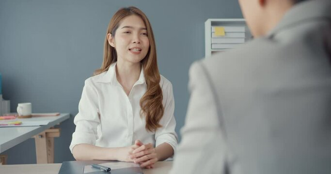 Young Asia businesswomen applicant pass job interview for enterprise company position or during corporate business meeting sitting on office desk at workplace. Hire candidate at job interview concept.