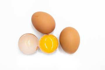 Two whole eggs and one broken isolated on a white background.