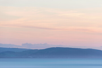 Fototapeta na wymiar Stunning landscape image of pastel color sunset over ocean giving lovely soft dreamy relaxing feel