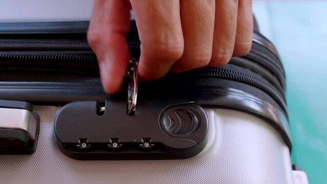 close up hand man close suitcase with combination lock.