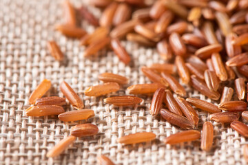 closeup of raw red rice seeds on sack