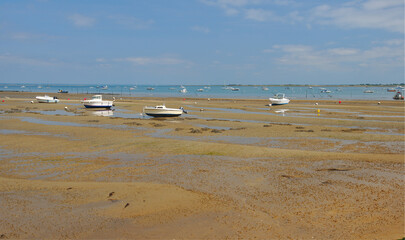 Boats on the sand beach during ebb, Brittany, France.