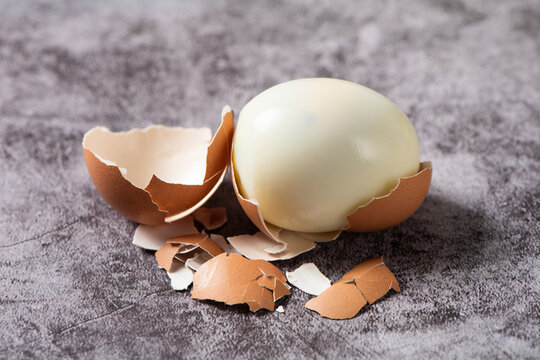 Peeled boiled eggs with eggshell on table