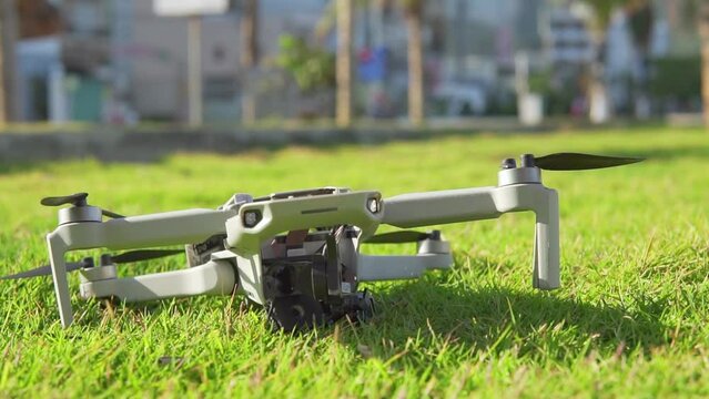 Accident with a drone. Damaged quadcopter falls on green grass