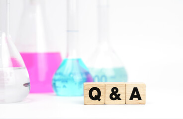 QandA word on wooden cubes and chemical glassware. Wood modules with QandA text. Wooden bricks...