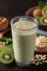 Glass of tasty kiwi smoothie with oatmeal on wooden table