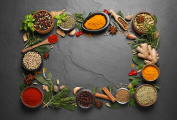 Fototapeta na wymiar Frame of different herbs and spices on black table, flat lay. Space for text
