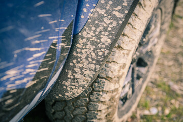 Close-up of a muddy wheel. Big tire of an off-road vehicle with mud. Splatters of mud on the side of the pick-up. Adventure, outdoor, 4x4, extreme, travel, mountain excursion concept. Vehicle off road