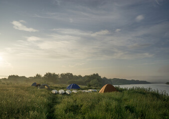 Tents in the morning sunlight in the fog.