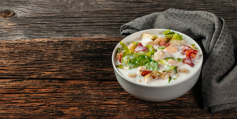 Traditional Russian cold soup okroshka with fresh potato, cucumber, tomato, boiled eggs and kefir. Flat lay, wooden background, top view