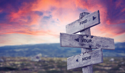 find your niche text quote caption on wooden signpost outdoors in nature with dramatic sunset skies. Panorama crop.