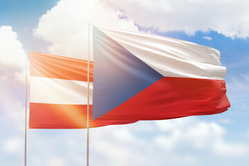 Sunny blue sky and flags of czechia and austria